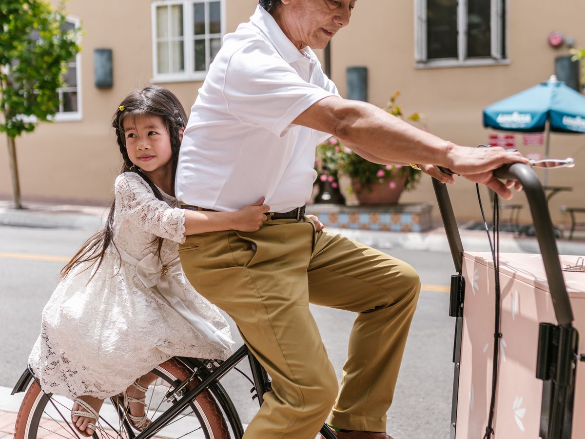 Vuxen som cyklar med ett barn i en lådcykel
